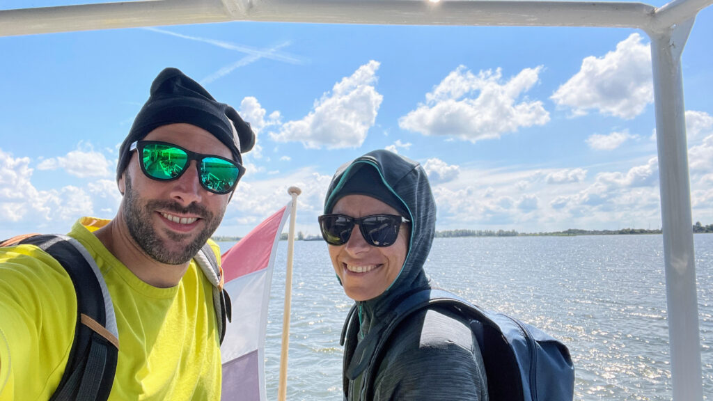 Couple’s selfie on the open deck of a ferry under blue skies during a cycling vacation in the Netherlands