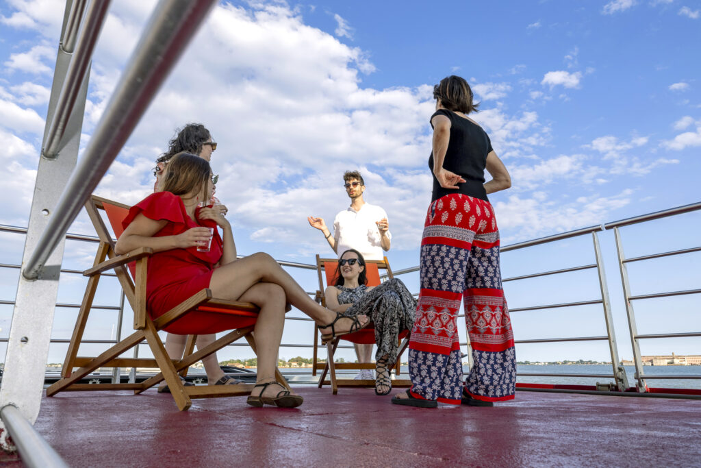People sitting on the deck of the ship talking